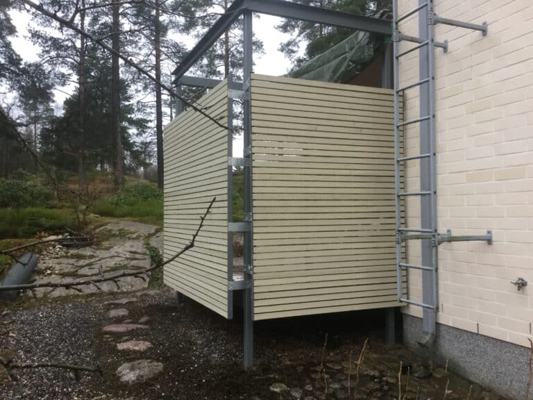 Vaalean ulkoverhouksen työvaihe ja rakennustelineet.